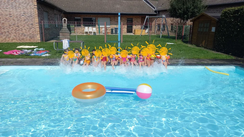 Kinder sitzen am Pool und Spielzeug schwimmt im Wasser