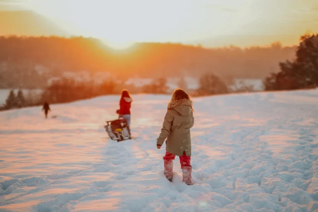 Kinder laufen durch den Wintertraum bei Sonnenuntergang in Merkstein